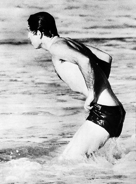 Prince Charles wearing swimming trunks paddling in the sea at Bondi Beach during his