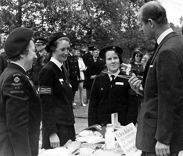 Prince Philip, Duke of Edinburgh, questions one of the Red Cress Cadets about the use of