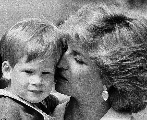 Princess of Wales holds her young son Prince Harry on holiday in Majorca, Spain