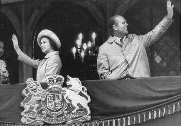 Queen Elizabeth II and Prince Philip wave to the crowds from a balcony at Durham Town