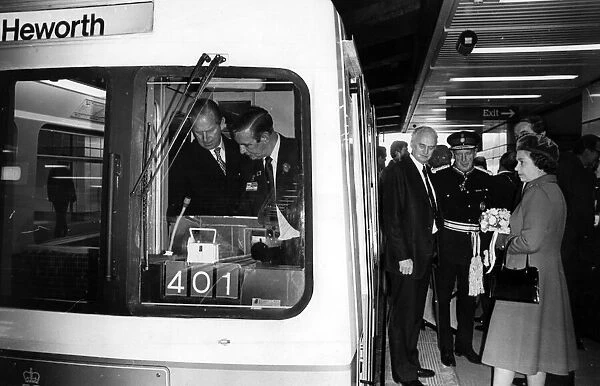 The Queen waits while Prince Philip, Duke of Edinburgh takes in a Metro tram driving
