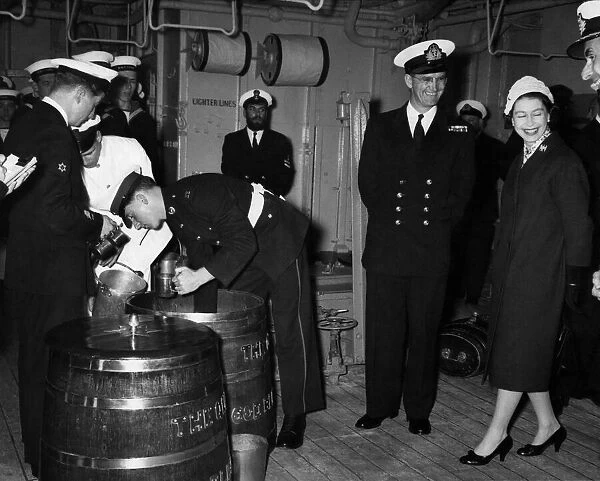 The Queen watches Officer B. R. J. Hailstone issuing the rum ration. April 1959 P009235