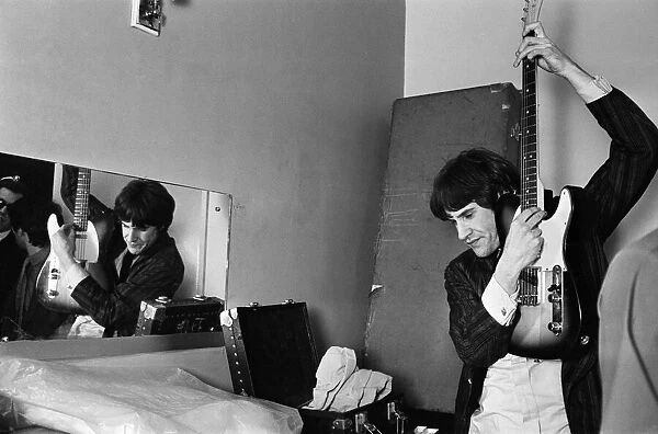 Ray Davies of The Kinks pop group rehearsing in their dressing room before a concert