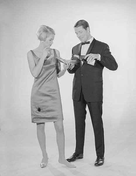 Reveille Studio Champagne from a slipper. Models pat Hinwood and Ray Curtis. Circa 1960