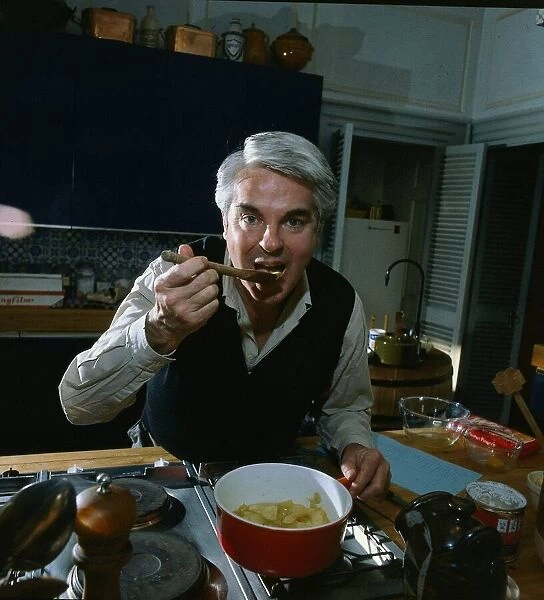 Robert Carrier tasting the meal he is cooking April 1981