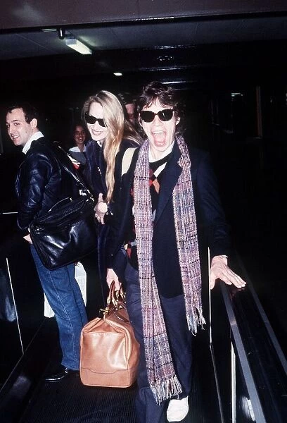 Rolling Stones singer Mick Jagger at London Heathrow Airport with Jerry Hall before