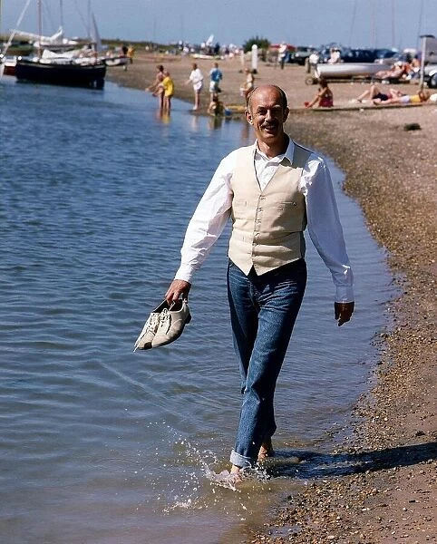 Roy Marsden actor walking along beach paddling in water