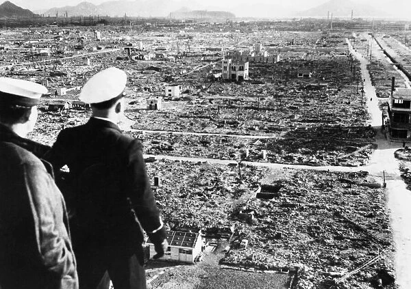 A Royal Navy officer and rating looking across the centre of damage at Hiroshima several