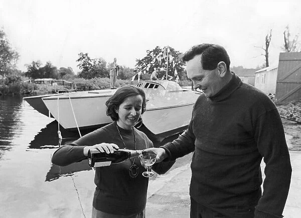 Sailor Donald Crowhurst celebrates with a glass of champagne after the launching of his