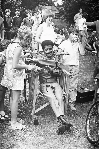 Sammy Davis Junior signing autographs whilst on location of 'One More Time'