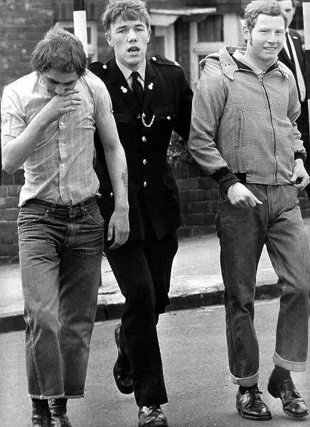 Two skinheads are led away by a policeman on 9th May 1971