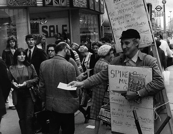 Spike Milligan actor with sandwich board handing out notices for a concert in which he