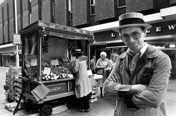 Street trader Albert Sayers wearing a straw boater hat and striped fruit embroidered