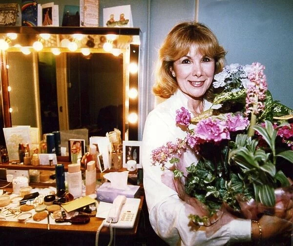 Susan Hampshire holding bouquet of flowers in her dressing room after appearing in Noel
