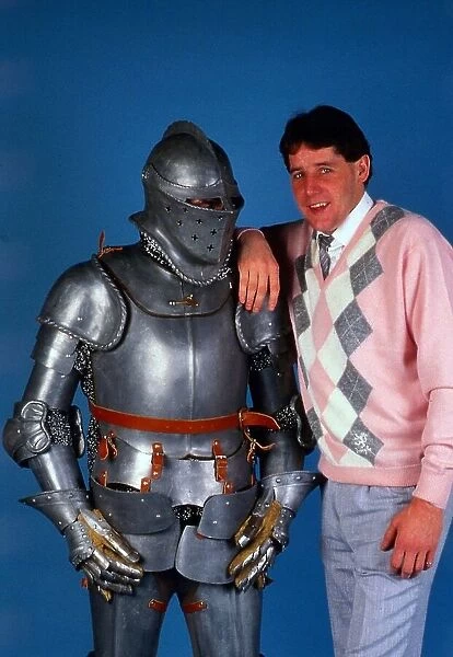 Ted McMinn leaning on suit of armour October 1986