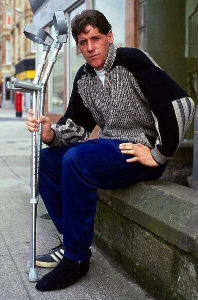 Ted McMinn sitting on wall with crutches September 1986