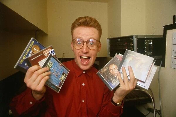 TV presenter Bryan Burnett holding various CD s