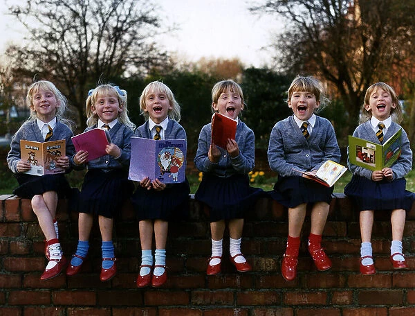 Walton Sextuplets holding story books while sitting on a wall DBase
