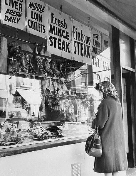 Woman looking through window of butchers shop, Cardiff, Wales, 2nd October 1967