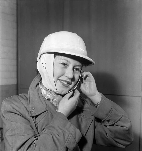 Woman strapping on her crash helmet. October 1952 C5018