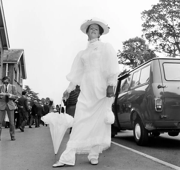Woman wearing long white dress with matching hat and umbrella on the first day of Royal
