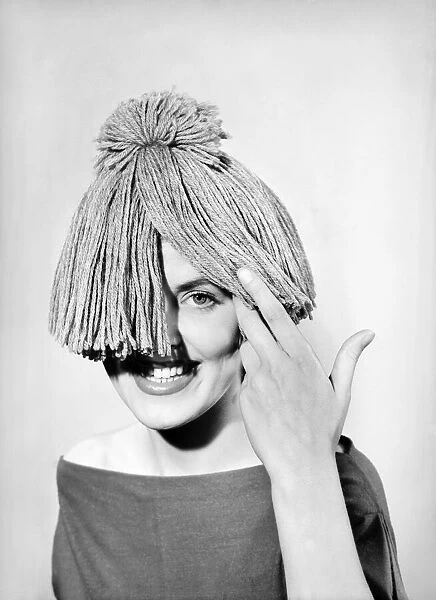 Woman wearing mop hat. 1955