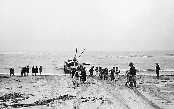 Women pull the lifeboat ashore at Cresswell lifeboat station in Northumberland