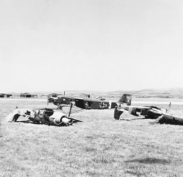 Wrecked German fighters on their backs beside a damaged Ju