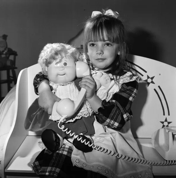 A young girl plays with her Cabbage Patch Dolls. 5th November 1987