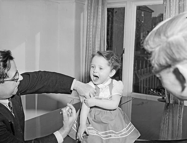 A young patient looks on with trepidation whilst having her polio vaccination