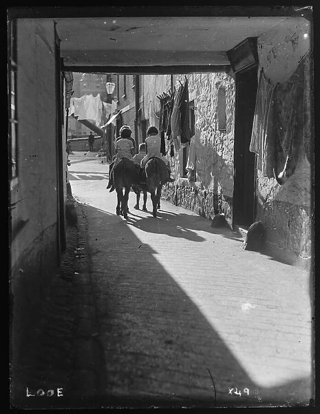 Children on donkeys, passageway by Arch House, Fore St, East Looe