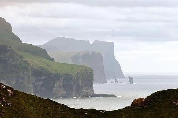 Famous Risin og Kellingin rocks and cliffs of Eysturoy and Streymoy Islands seen from Kalsoy Island. Faroe Islands, Denmark. Landscape photography