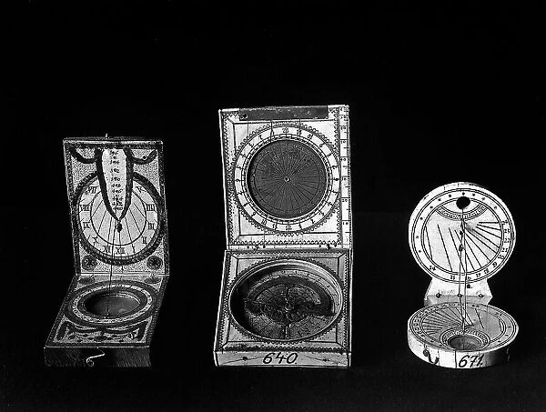 The image depicts three portable ivory solar clocks with compass. The three instruments are preserved in the Museum of Science History of Florence. The photo was taken for the occasion of the Exhibition of the History of Science from 1929, Florence
