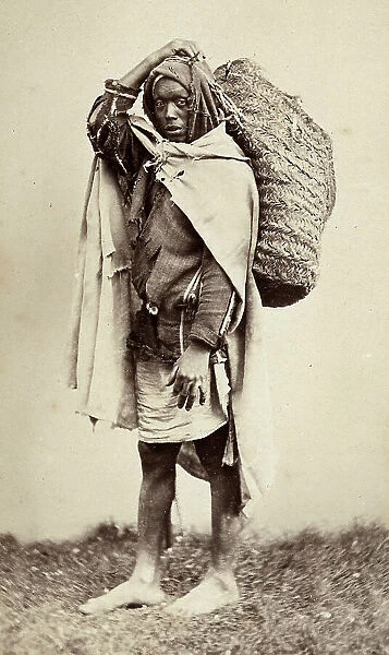 Portrait of a young coloured Moorish man with a busket on his shoulder