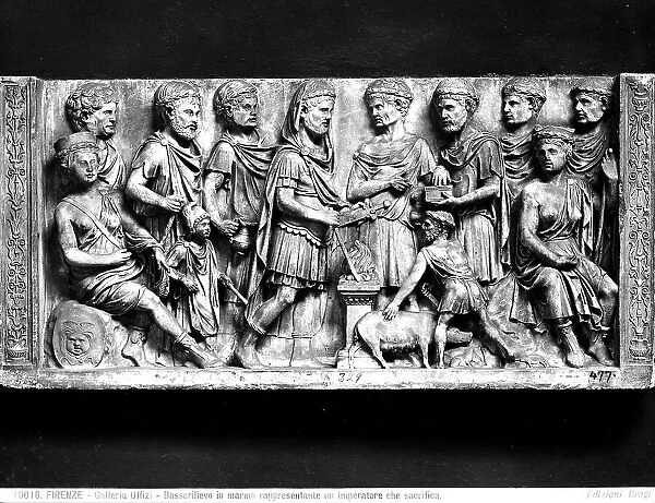 Roman bas relief in marble depicting a sacrifice scene. In the middle an emperor stands surrounded by various characters. The Uffizi Gallery