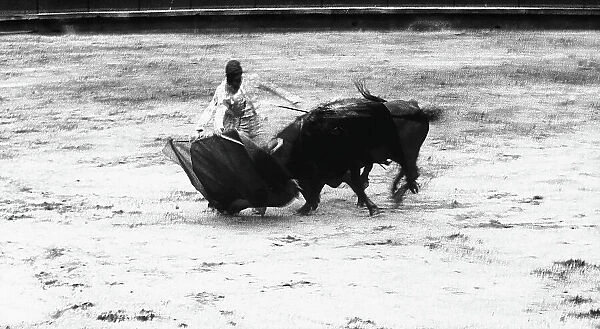 Snapshot of a bullfight with a toreador facing a bull