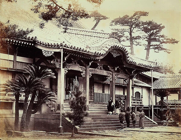 View of the Daidoongi Temple at Nagasaki. Two monks are portrayed on the flight of steps leading to the entry. In the foreground there is a shoulder view of four other people bowing before going up to the Temple