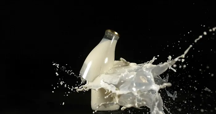 Framed Print : Bottle of Milk Exploding Print against Black Background Framed Print : Bottle of Milk Exploding Print against Black Background