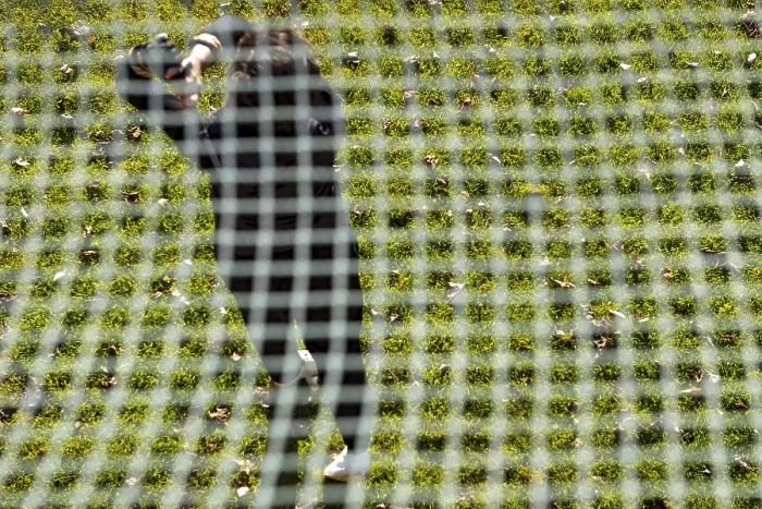 Framed Print : Golfer Training on Driving Range Behind a Net Print
