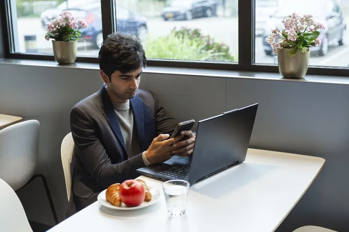 Framed Print : Indian Man Multitasking with Smartphone and Laptop Print Framed Print : Indian Man Multitasking with Smartphone and Laptop Print