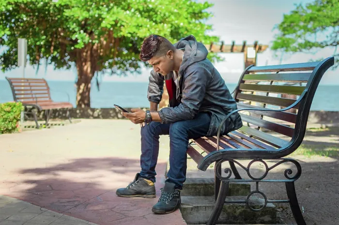Framed Print : Young Man on Bench Checking Phone Print Framed Print : Young Man on Bench Checking Phone Print