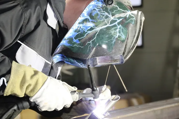 Framed Print : Metalworker during welding work in his workshop Print