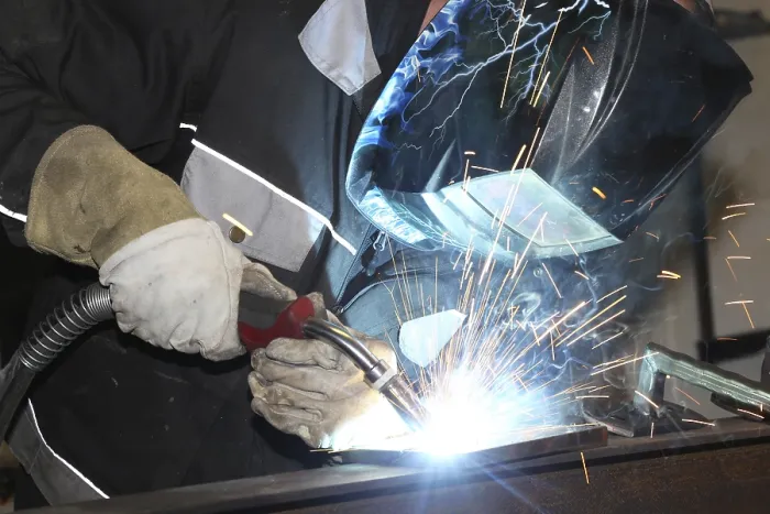 Framed Print : Metalworker during welding work in his workshop Print