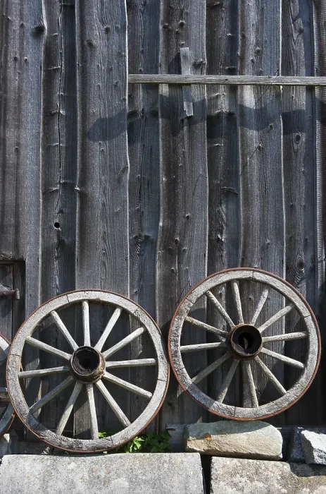 Framed Print : Two old wagon wheels in front of a barn, Bad Schallerbach print