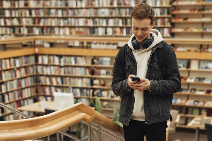 Framed Print : Smiling Guy with Smartphone in Library Print Framed Print : Smiling Guy with Smartphone in Library Print