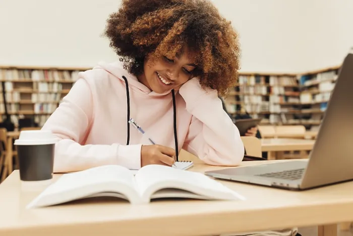 Framed Print : Smiling Student Writing in Library Print Framed Print : Smiling Student Writing in Library Print