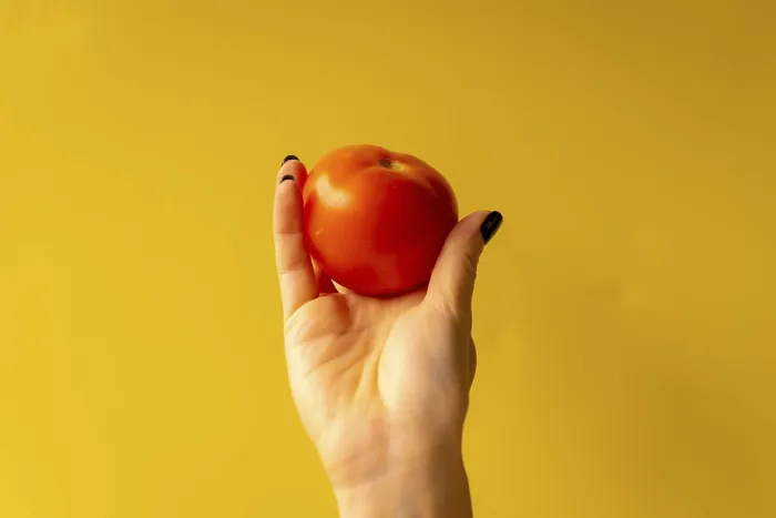 Framed Print : Woman's Hand with Tomato on Yellow Background Print Framed Print : Woman's Hand with Tomato on Yellow Background Print