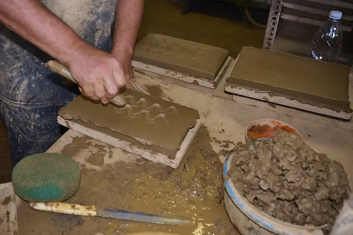Framed Print : Worker's Hand Carving Patterns in Clay Bricks Print