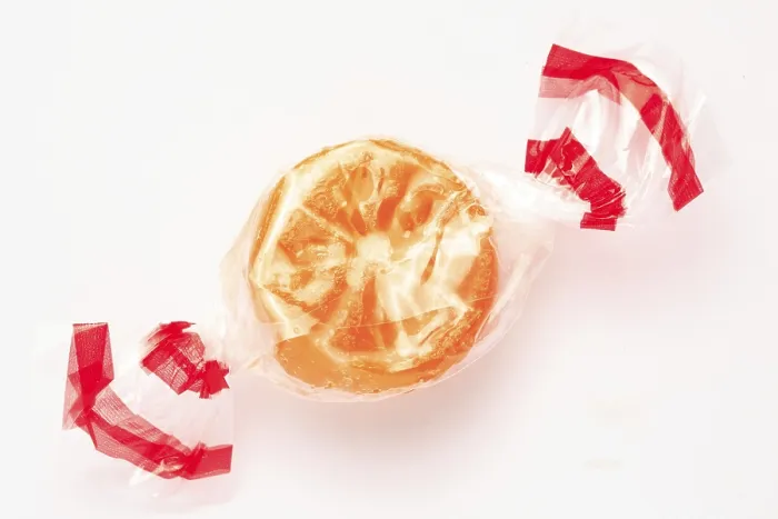 Framed Print : Wrapped fruit candy in the shape of an orange slice Print