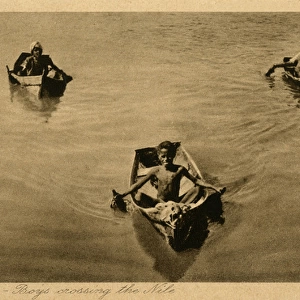 Aswan, Egypt - Three boys crossing the Nile in small boats